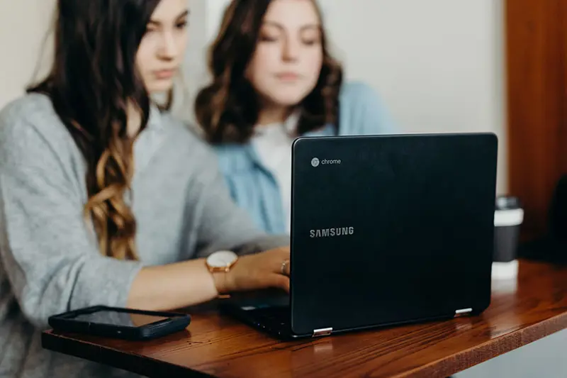 To personer ved en laptop
