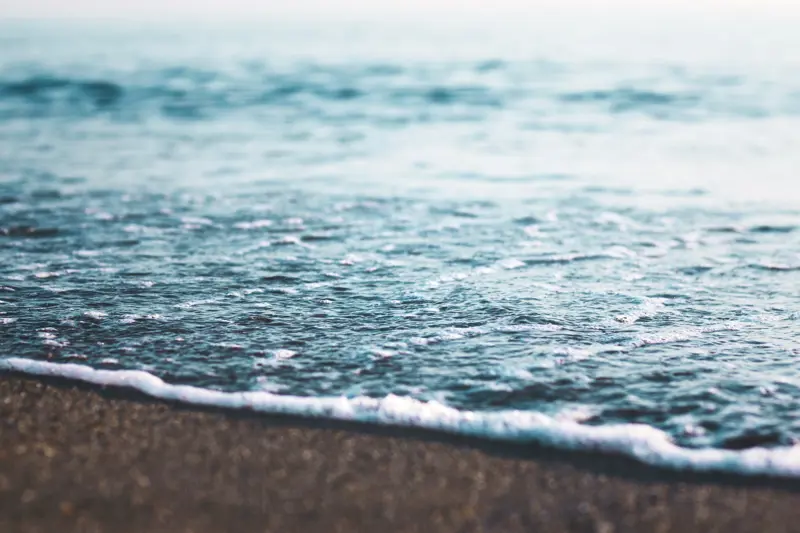 Vann som siver inn over stranden